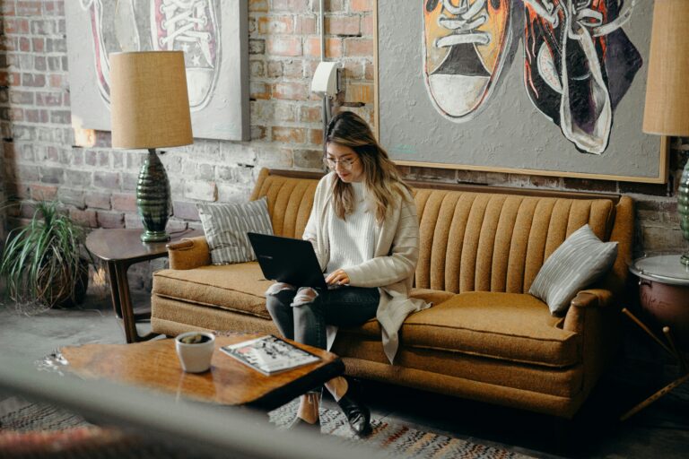 Girl working on laptop whilst sitting on a couch, Working on an online income idea without relying on social media